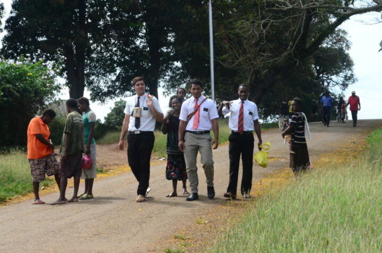 Locals walk with foreigners in Daru, Papua New Guinea.